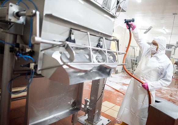 Worker washing down equipment